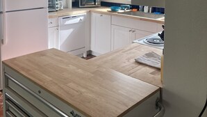 Una cocina con armarios blancos, un microondas, un tostador y un lavamanos.