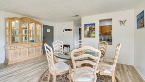 A dining area with a glass-top table surrounded by four chairs, a wooden cabinet, and a patterned rug. - 10 Mi to Dtwn Ocala: Dog-Friendly Home w/ Fire Pit (Ocala)
