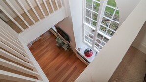 A room with a wooden floor, a white radiator, and a window with a view of greenery outside. - 2 The Reformed Church (Alnwick)