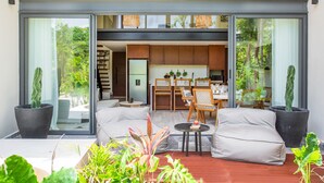 Uma sala de estar moderna com um sofá, uma mesinha e plantas em vasos.