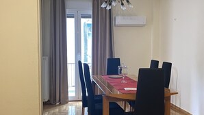 Un comedor con una mesa de madera, sillas negras y una lámpara de araña.