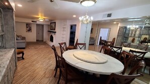 A dining area with a round table, wooden chairs, a chandelier, and a fireplace. - Huge 4,080 SqFt  cul-de-sac Home (Mesa)