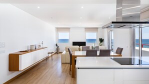 Un salon moderne comprenant un canapé, une table à manger et un coin cuisine.