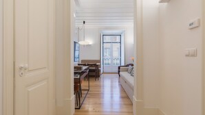 Un pasillo con comedor, un sofá y una ventana con vistas.