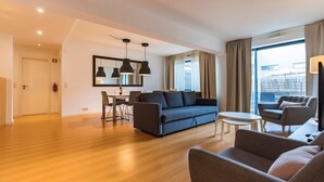 A modern living room with a sofa, armchairs, a dining table, and pendant lights. - Downtown apartment w/terrace (Lisboa)