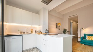 A modern kitchen with white cabinetry, a built-in dishwasher, and a central island. - Bravissimo Pont Areny, modern 3-bedroom apartment next to the historic center (Girona)