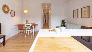 Une cuisine moderne dotée d’un îlot central, d’un plancher en bois et d’un coin repas avec des chaises et une table.