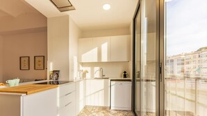 Une cuisine moderne avec des armoires blanches, un plan de travail en bois et un sol carrelé à motifs.