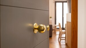 A modern interior with a grey cabinet and a golden door handle. - Bravissimo Sant Martí; Cozy 1-bedroom apartment in Girona's historic center (Girona)