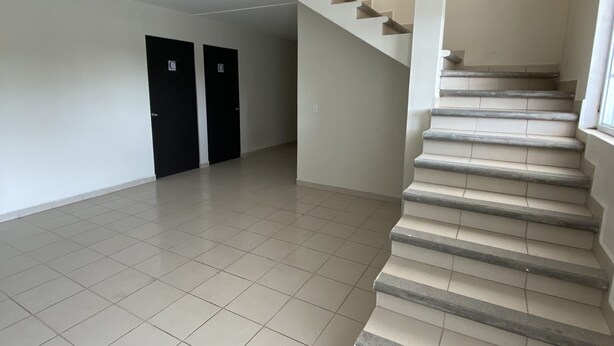 A spacious, empty stairwell with beige tiled floors and a modern design. - room rental (Tehuacán)