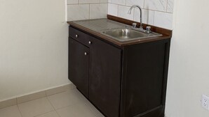 A small kitchen with a sink, cabinets, and a white countertop. - room rental (Tehuacán)