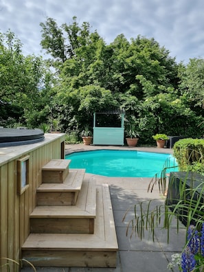 Una piscina al aire libre, sillones reclinables de piscina