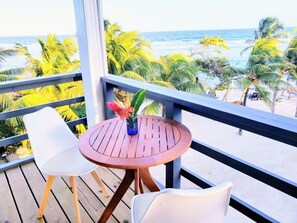 Enjoy a serene ocean view from this balcony, featuring a table and chairs perfect for taking in the sights.