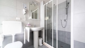 A modern bathroom with a toilet, sink, and shower.