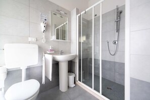 A modern bathroom with a toilet, sink, and shower. - Anny Hotel (Jesolo)