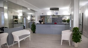 Un intérieur moderne comprenant un comptoir d’accueil, un espace détente et un bar.