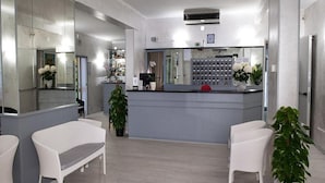 A modern reception area with a counter, seating, and a display of toiletries.