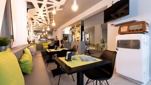 Ein modernes Restaurant mit einer langen Theke, einer Sitzgruppe mit Kissen und einem Vintage-Radio.