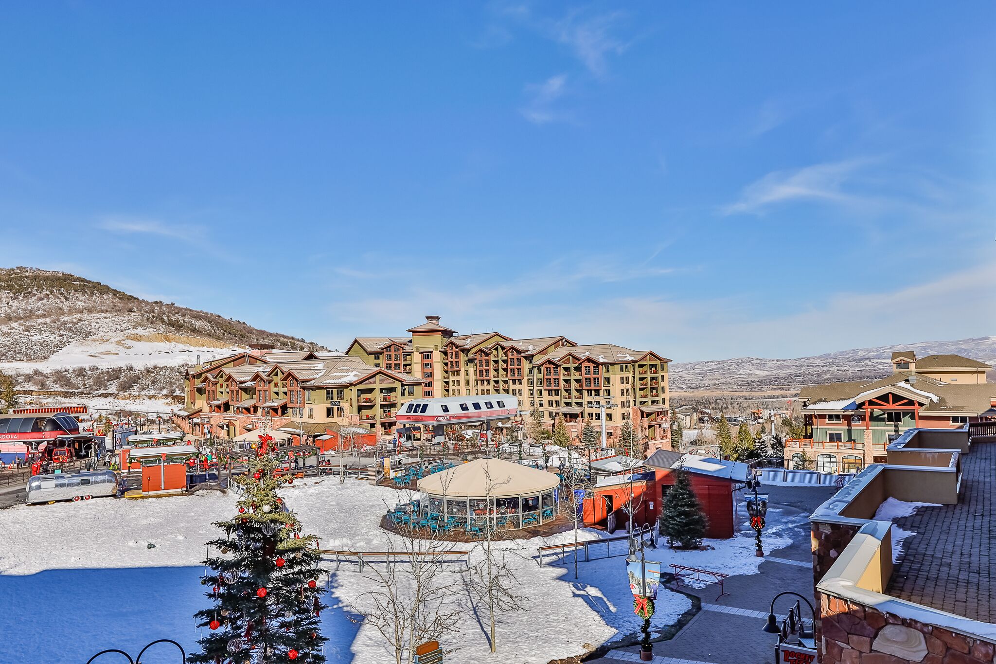 A hotel with multiple floors, a central courtyard, and a view of snow-covered mountains.