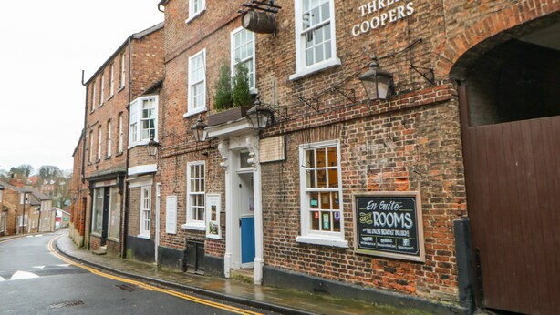 A brick building with a sign reading "The Three Coopers" and another sign for "En Suite Guest Rooms". - Firkin Cottage (Bedale)