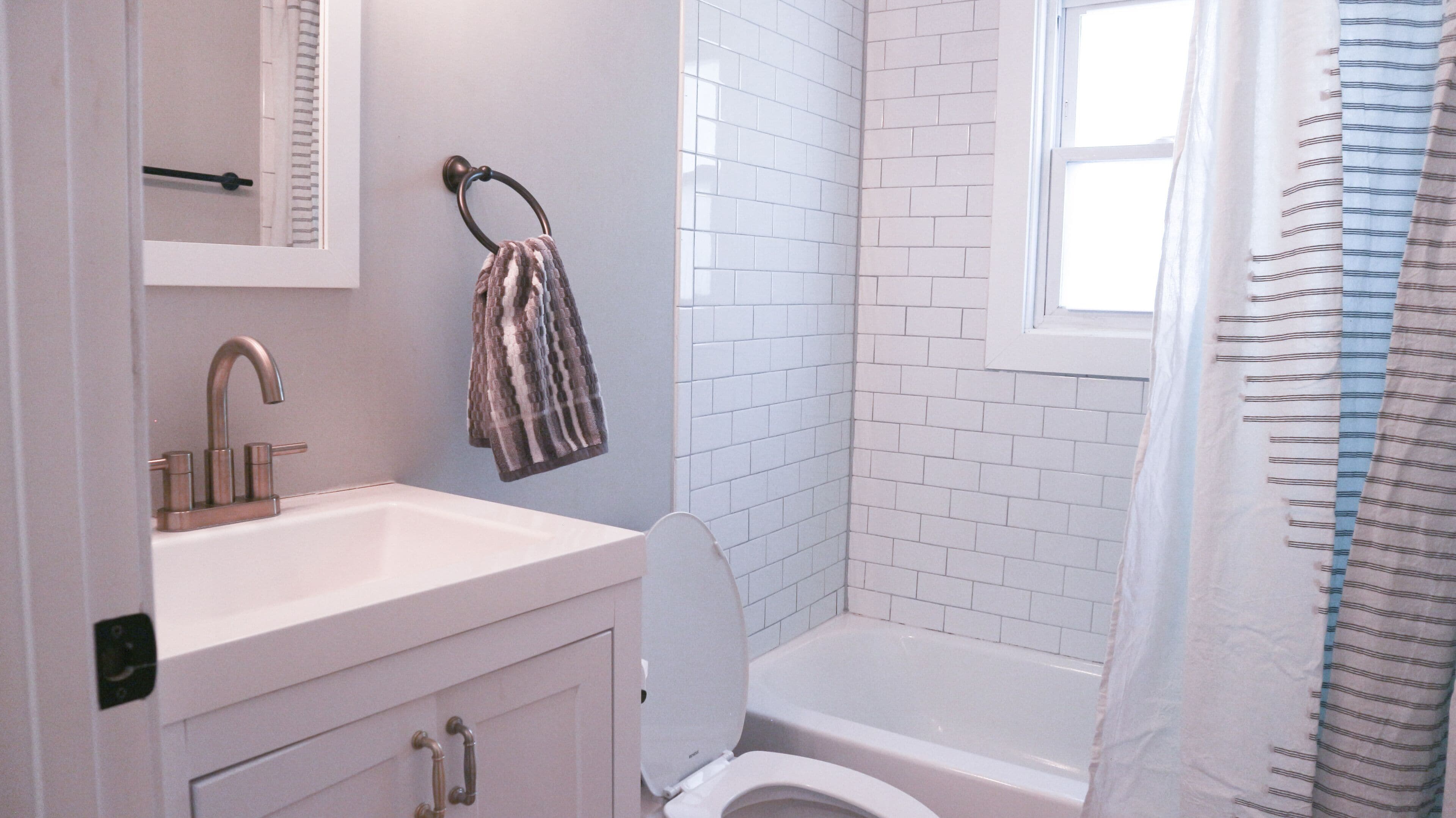 A bathroom with a white sink, a toilet, and a shower area.