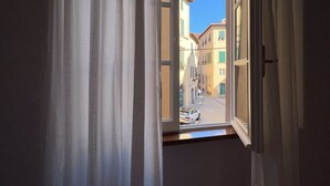 Una stanza con una finestra che si affaccia sulla strada.