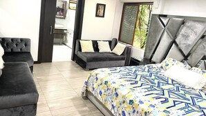A bedroom with a bed, two sofas, a dresser, and a door leading to another room. - CASA SUYTE LEGUIZAMON (Envigado)