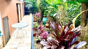 A narrow outdoor corridor with a small table and potted plants. - CASA SUYTE LEGUIZAMON (Envigado)