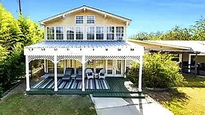 A two-story house with a covered porch and a small deck.