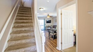 A staircase with carpeted steps leading to a dining area with a table and chairs. - Beach Retreat I HotTub I FirePit I Near Cape May I 7 Beach Passes I 4 Bikes (Lower Township)