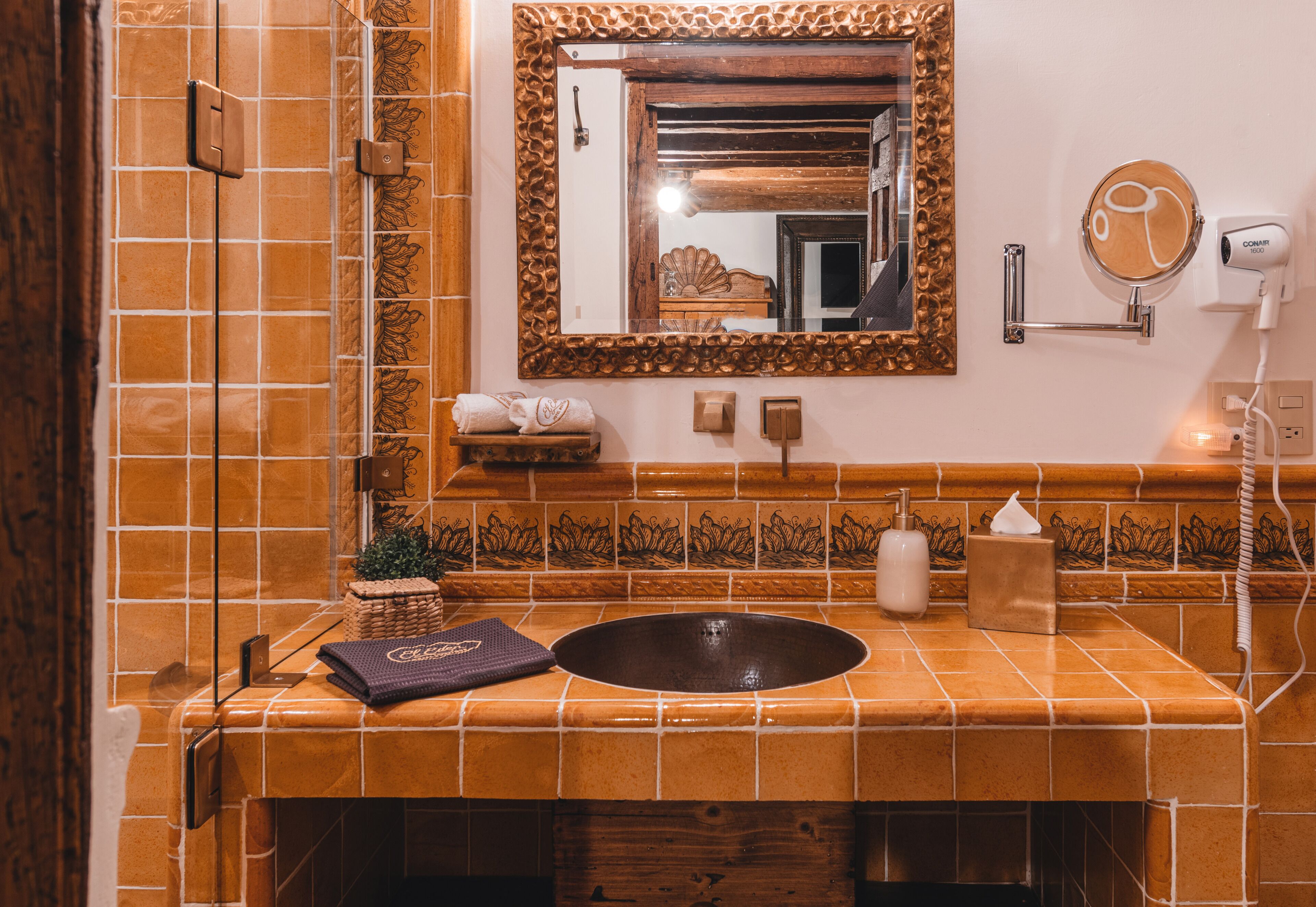 A bathroom with a large mirror, a sink, and a towel rack.