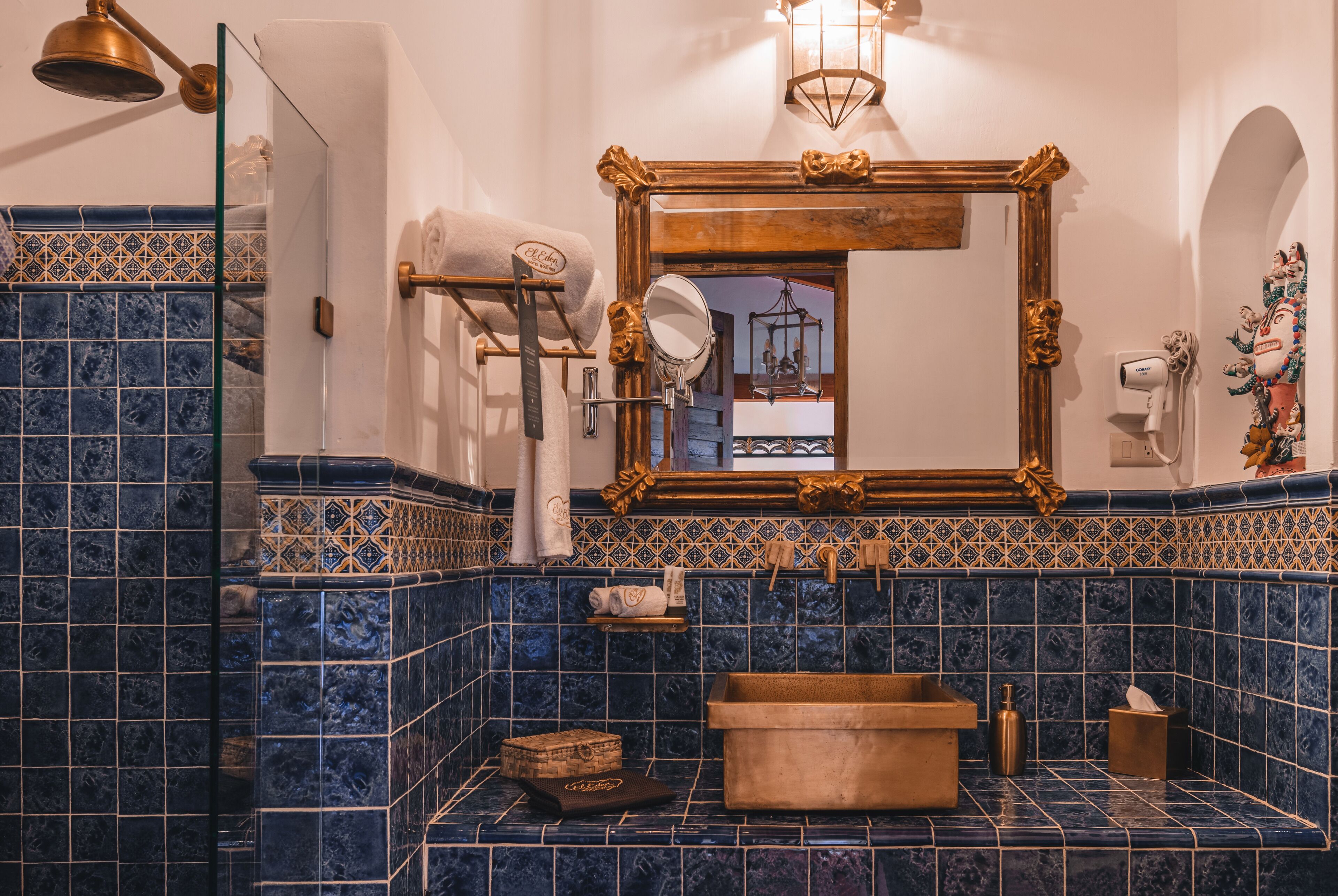 A bathroom with a large mirror, a wooden basin, and a towel rack.