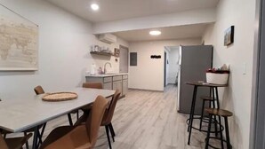 A compact kitchen with a dining area, a small bar stool, and a refrigerator. - Elk Loft in Downtown Custer, Sleeps 8, 2 full bath (Custer)