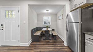 A kitchen with a built-in refrigerator, a wooden bench, and a window with blinds. - Big House Downtown Greensboro (Greensboro)