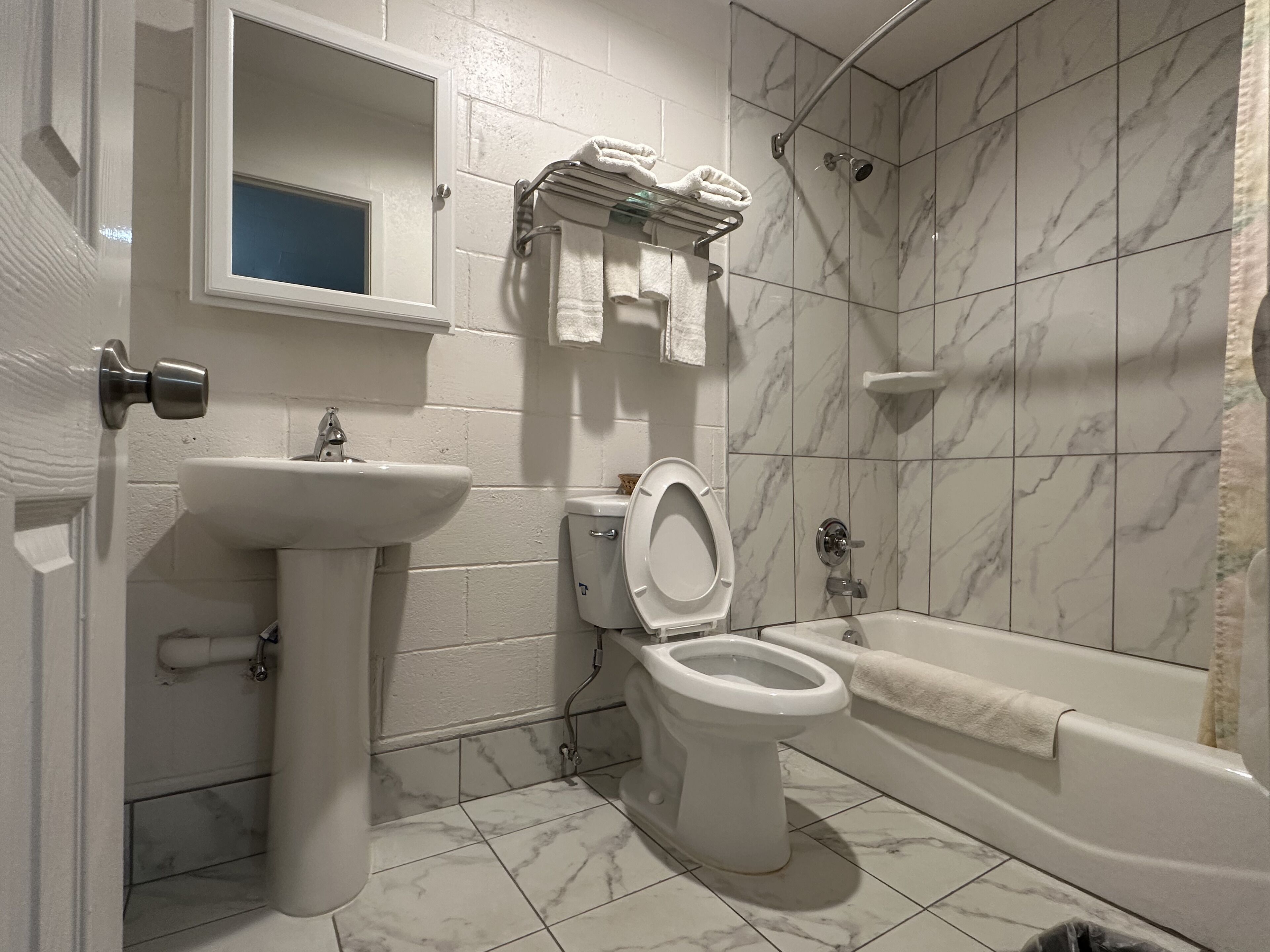 Een badkamer met toilet, wastafel en bad.
