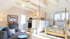 A bedroom with a bed, a dresser, a desk, and a chair.