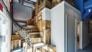 A staircase with wooden steps and a netted swing, leading to a door. - Hangar 18 @ Area 51 | Themed | Pet Friendly (Hurricane)