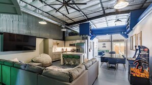 A modern kitchen with white cabinets, a central island, and bar stools. - Hangar 18 @ Area 51 | Themed | Pet Friendly (Hurricane)