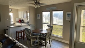 A kitchen with a dining area, a ceiling fan, and a view of the outdoors.