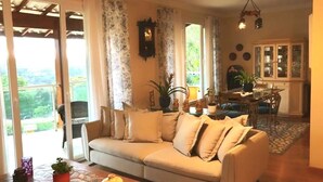 A cozy living room with a sofa, a dining table, and a kitchen area. - Large house in a gated community, 3 bedrooms, 5 bathrooms and a large backyard. (Atibaia)
