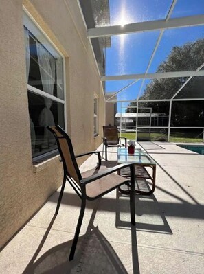 Enjoy a peaceful outdoor space with a glass table and two chairs, offering a clear view of the surrounding area.