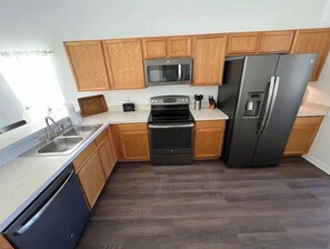 Fully equipped kitchen with a refrigerator, dishwasher, microwave, and oven.
