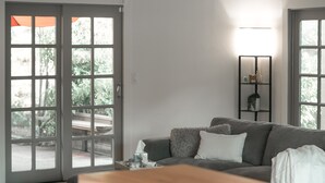 Ett modernt vardagsrum med en grå soffa, ett soffbord och en bokhylla.