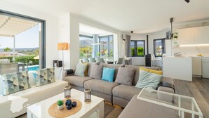 A modern living room with a sofa, a coffee table, and a view of the outdoors. - CostaBlancaDreams - Villa Hermosa in Calpe (Calpe)