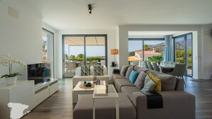 A modern living room with a sofa, TV, and a dining area with outdoor seating. - CostaBlancaDreams - Villa Hermosa in Calpe (Calpe)