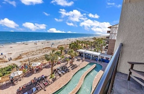 Un resort en la playa con piscina, sillas de descanso y vistas al océano.