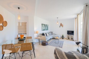 A modern living room with a sofa, coffee table, and dining area. - CostaBlancaDreams - Duplex Manzanera in Calpe (Calpe)