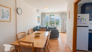 A dining area with a wooden table and chairs, a sofa, and a view of the outdoors. - CostaBlancaDreams - Casanova in Calpe (Calpe / Calp)