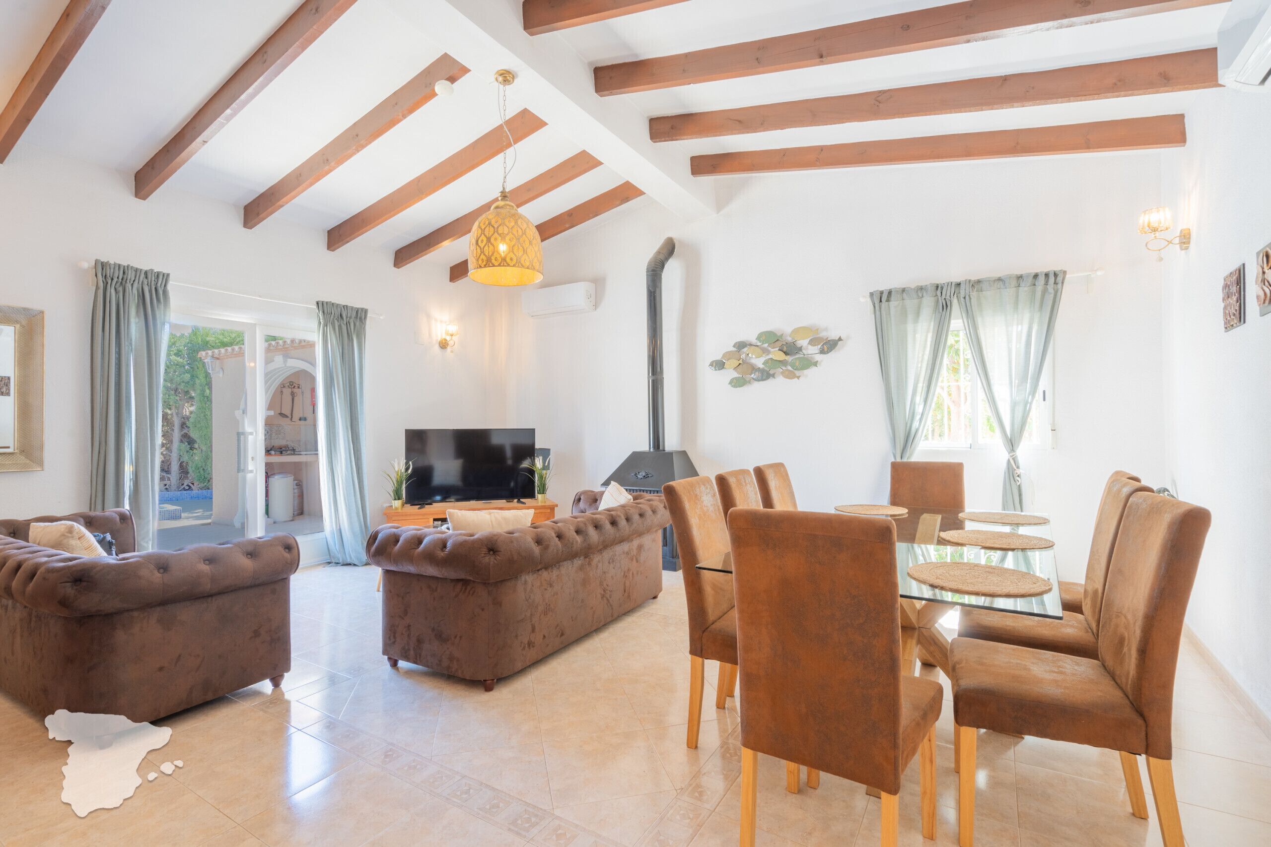 Een ruime woonkamer met een bank, fauteuils en een televisie.