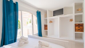 Een hotelkamer met een bed, een televisie en een kledingkast.